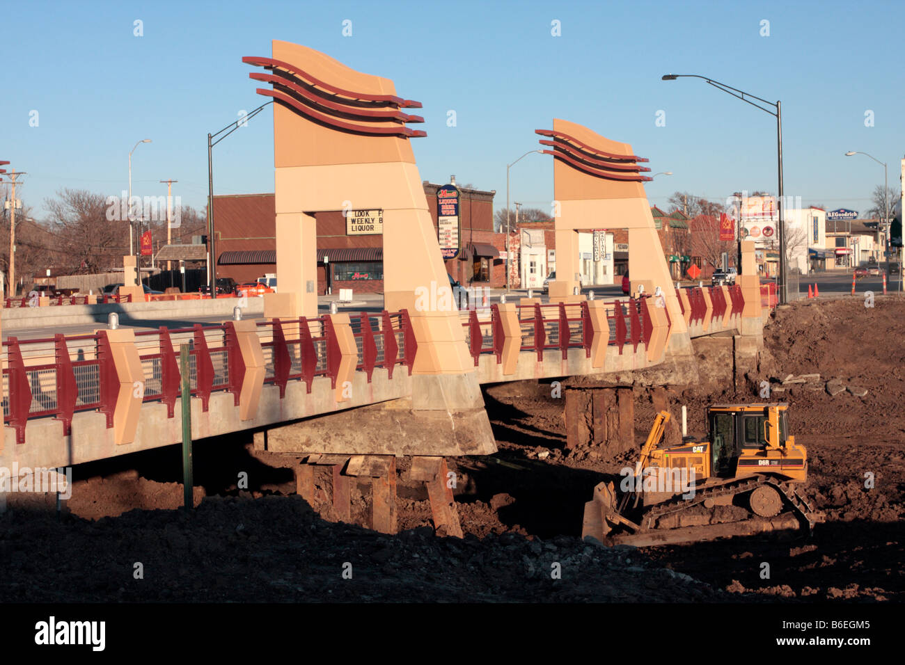 New bridge construction in urban area with CAT bulldozer in streambed underneath near exposed pilings. Stock Photo