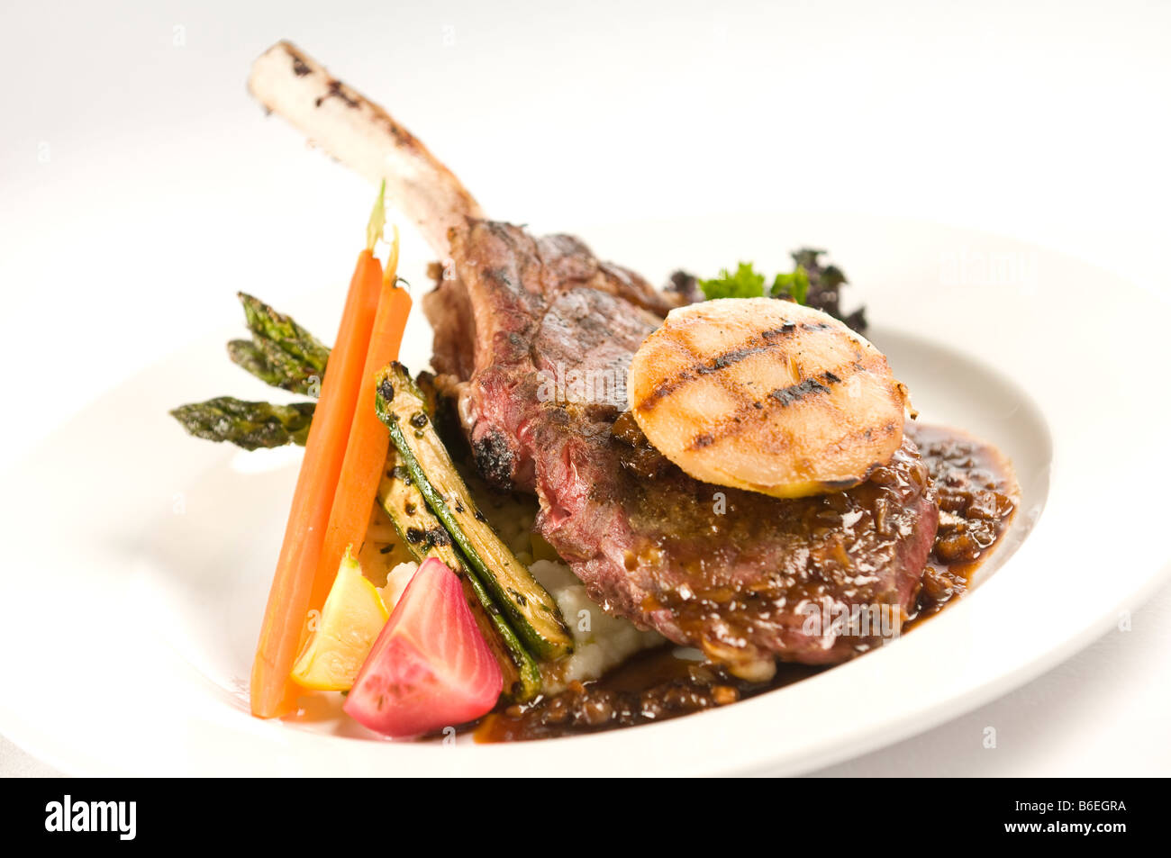 Veal chop with grilled pear and seasonal vegetables Stock Photo