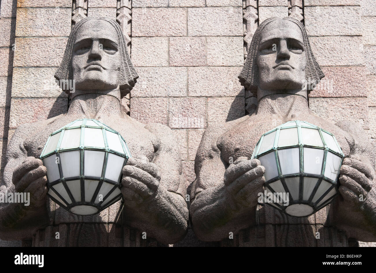 Stone statues holding spherical lamps that are part of the architecture