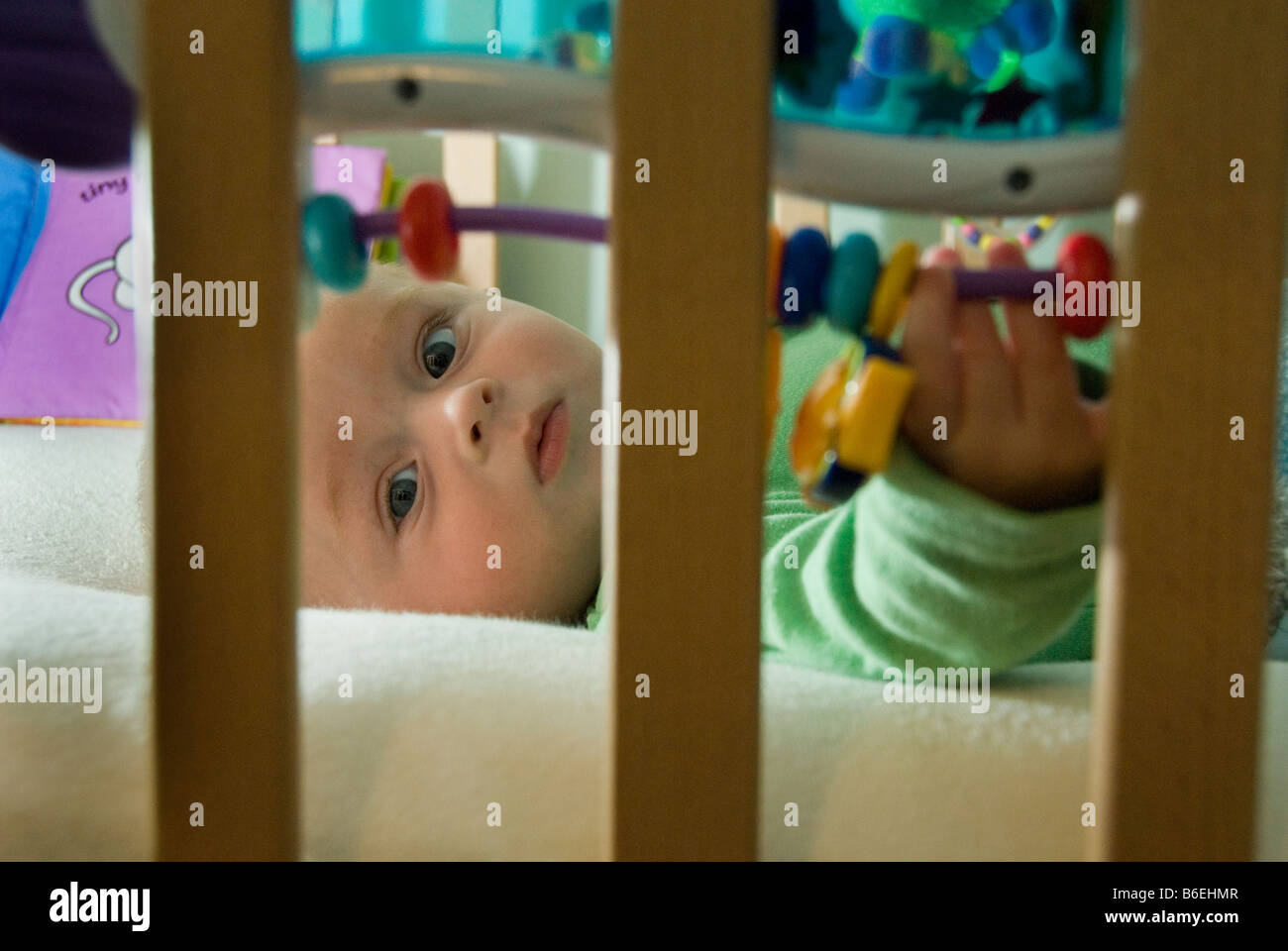 Looking through Cot Bars Close Up on Face of Baby Boy Lying in Bed