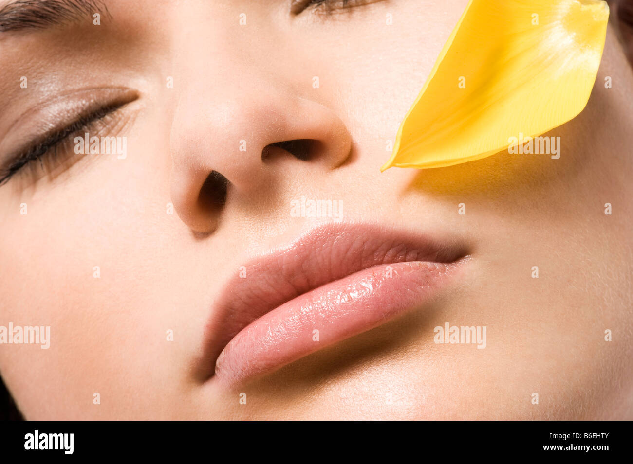 close-up of woman face with flower petal Stock Photo
