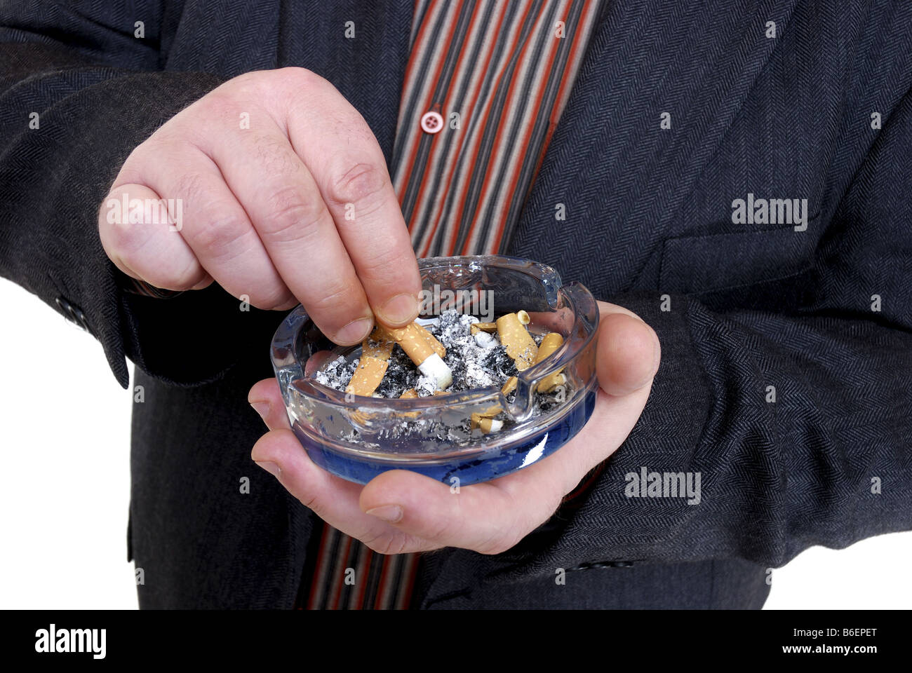 man stubbing out a cigarette in an ash-tray Stock Photo
