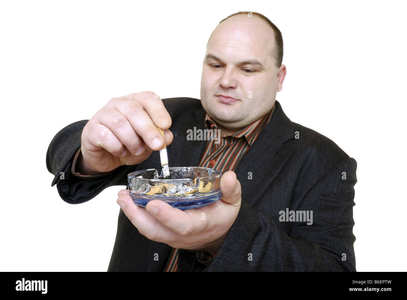 man stubbing out a cigarette in an ash-tray Stock Photo