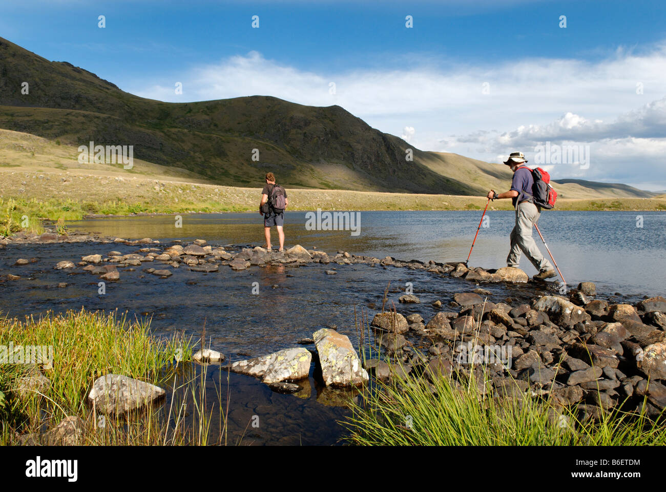 Hikers, trekkers crossing a river, Saylyugem Mountains, Tschuja Steppes, Altai Republic, Siberia, Russia, Asia Stock Photo
