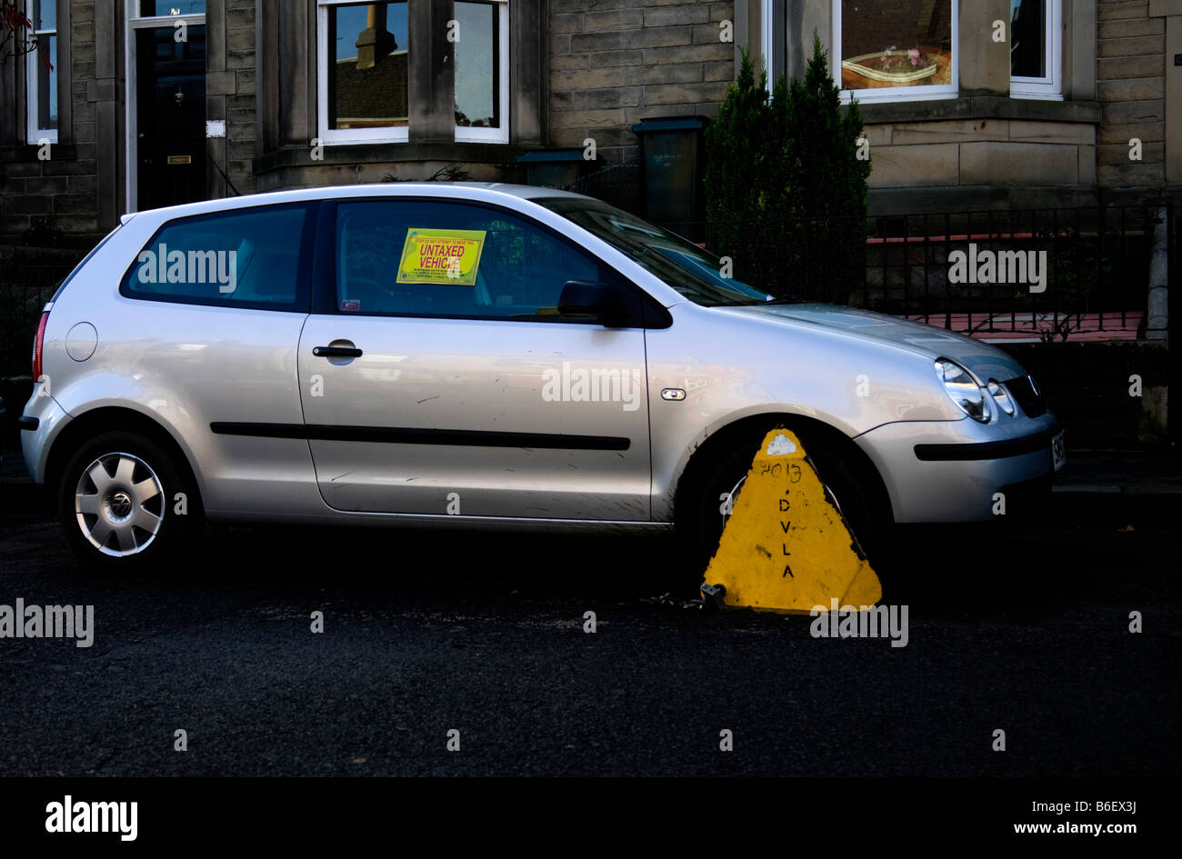 Silver Volkswagen car with DVLA clamp, due to not displaying a vehicle Exise Tax Disc Scotland Stock Photo