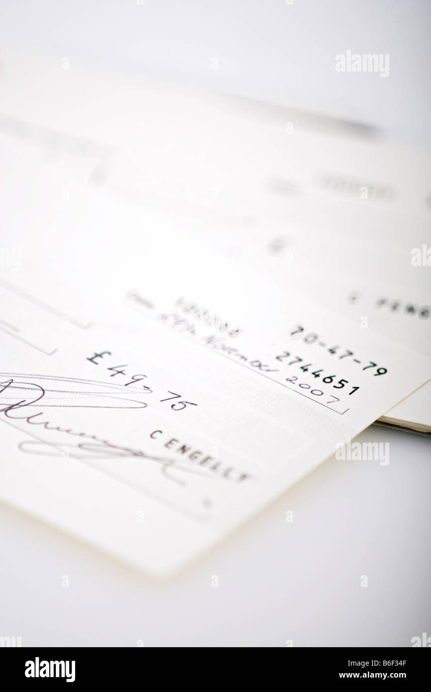 A cheque book with a signed cheque on a white background Stock Photo