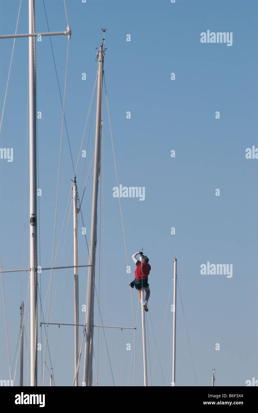 Sailor going aloft at the marina for mast top work. Stock Photo
