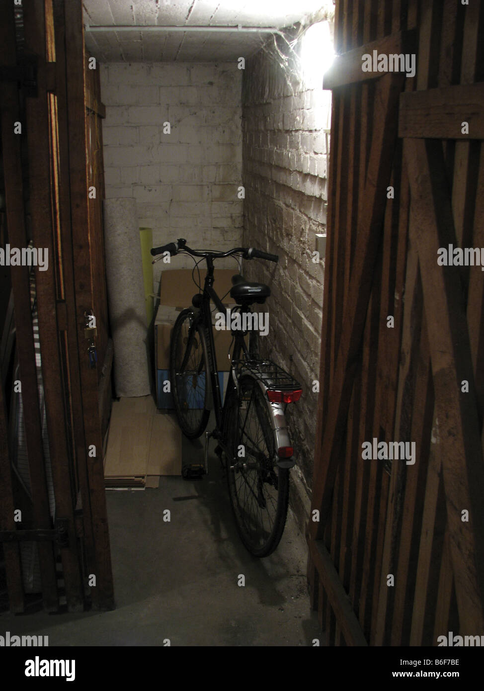 Bicycle standing in old dusty store room with other junk in the cellar of a house, Germany, Ruhr Area, Essen Stock Photo