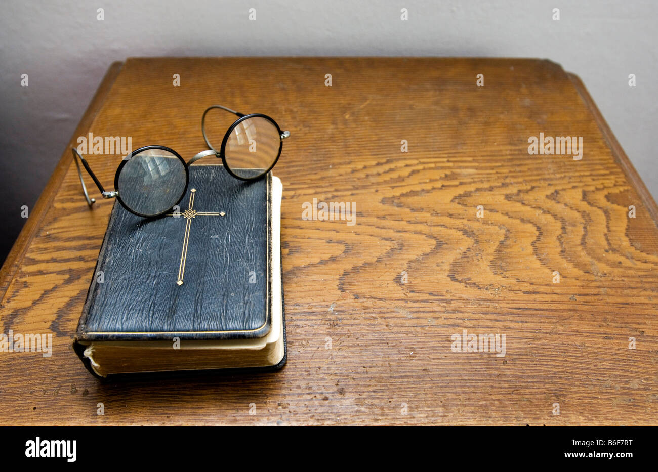 An old bible and glasses lying on a table Stock Photo