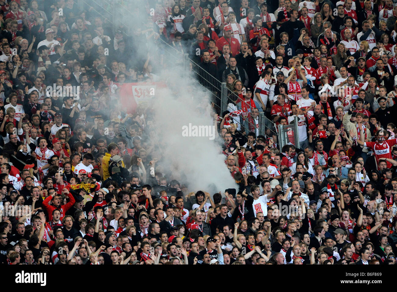 Hooligans igniting fireworks and smoke bombs in a fan block Stock Photo