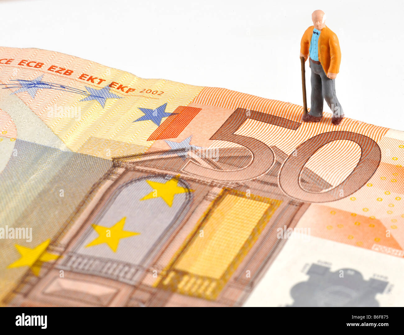 Senior citizen figure walking over a 50 Euro bank note, symbolizing retirement Stock Photo
