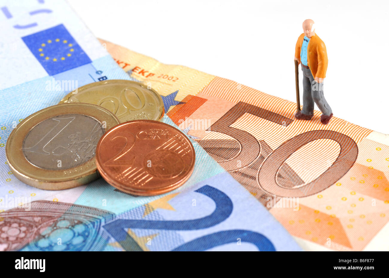 Senior citizen figure walking over a Euro bank notes and coins, symbolizing retirement Stock Photo