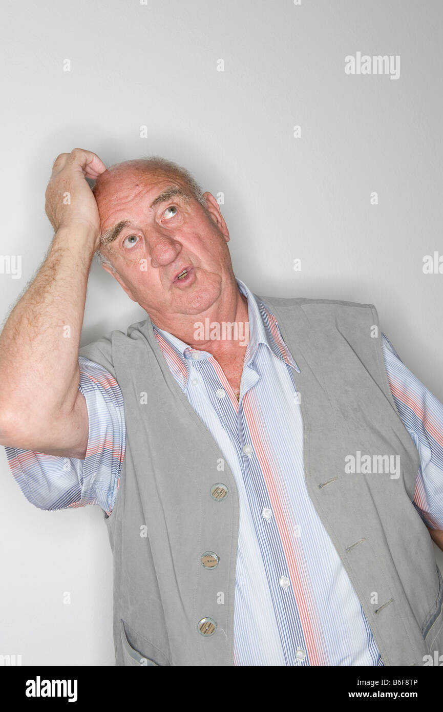 Elderly man acting, scratching his head Stock Photo