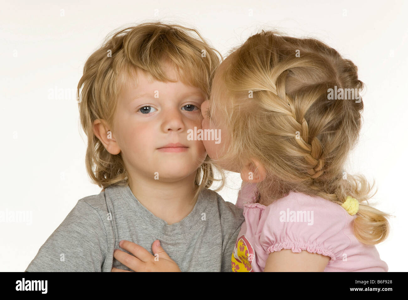 Girl, two years old, kisses boy, three years old, on the cheek Stock Photo