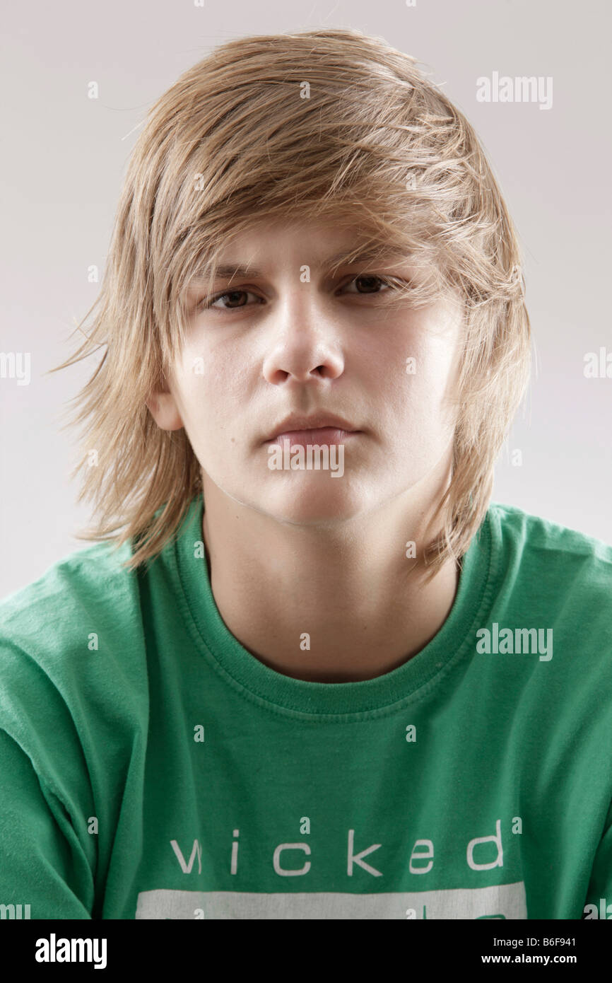 13 yearold boy wearing a green tshirt and looking annoyed Stock Photo Alamy