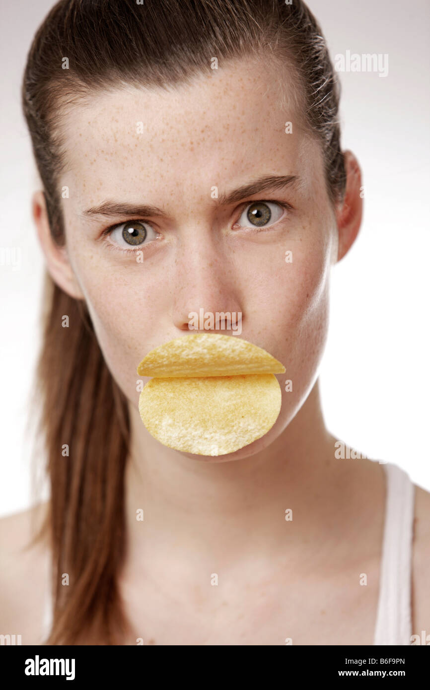 teenage-girl-woman-17-years-old-holding-chips-as-lips-in-her-mouth-B6F9PN.jpg