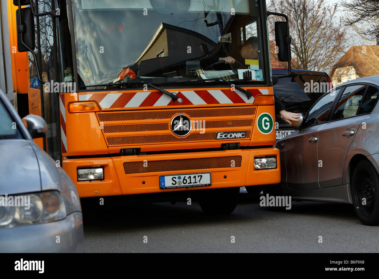 Driver of a garbage truck for the Stuttgart garbage company, called AWS or Abfallwirtschaft Stuttgart, is forced to fold back a Stock Photo