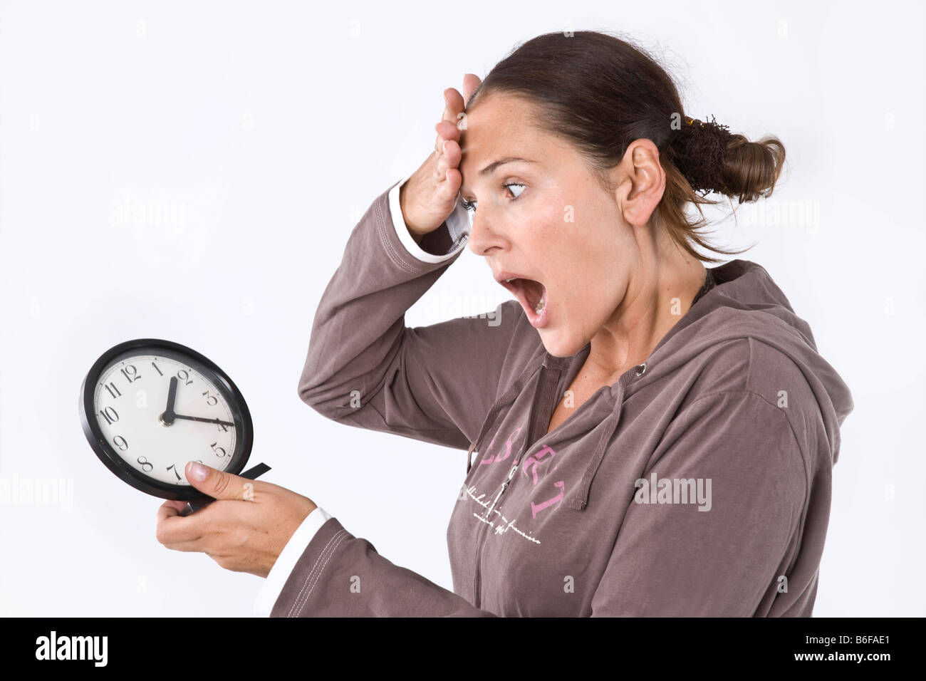 Girl looking at a clock in horror Stock Photo Alamy