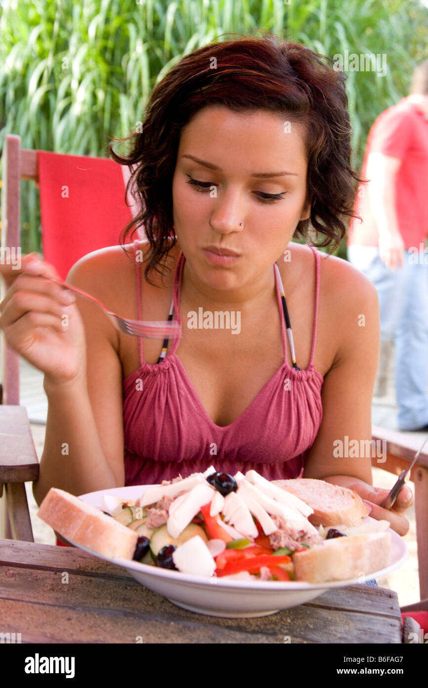 Girl eating salad at a beach bar Stock Photo