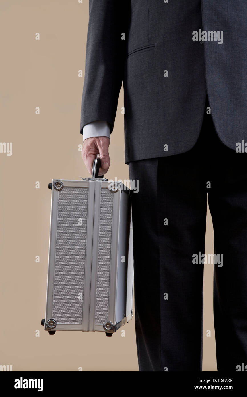 Hand of a businessman holding a metal case Stock Photo