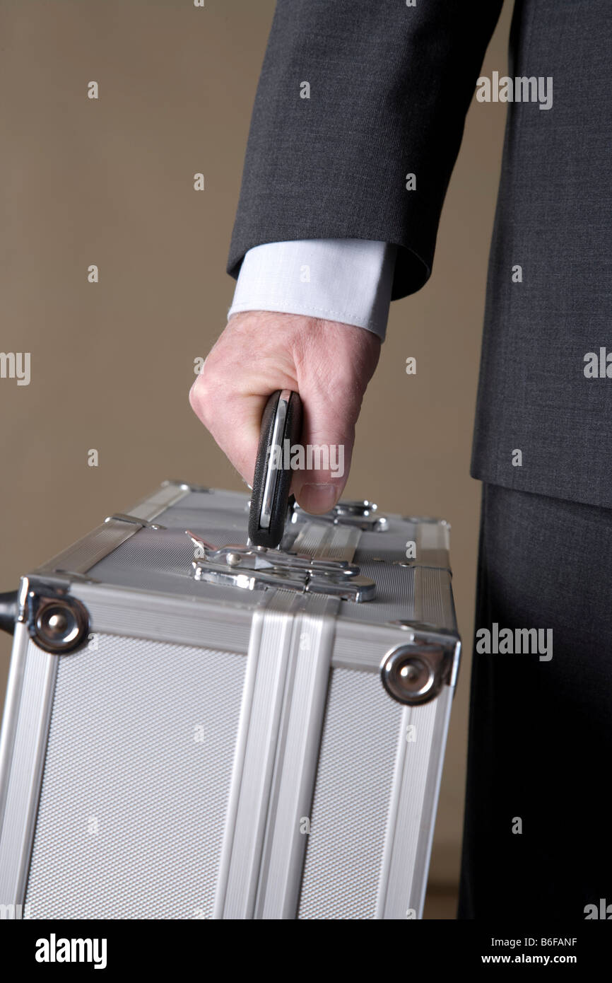 Hand of a businessman holding a metal case Stock Photo