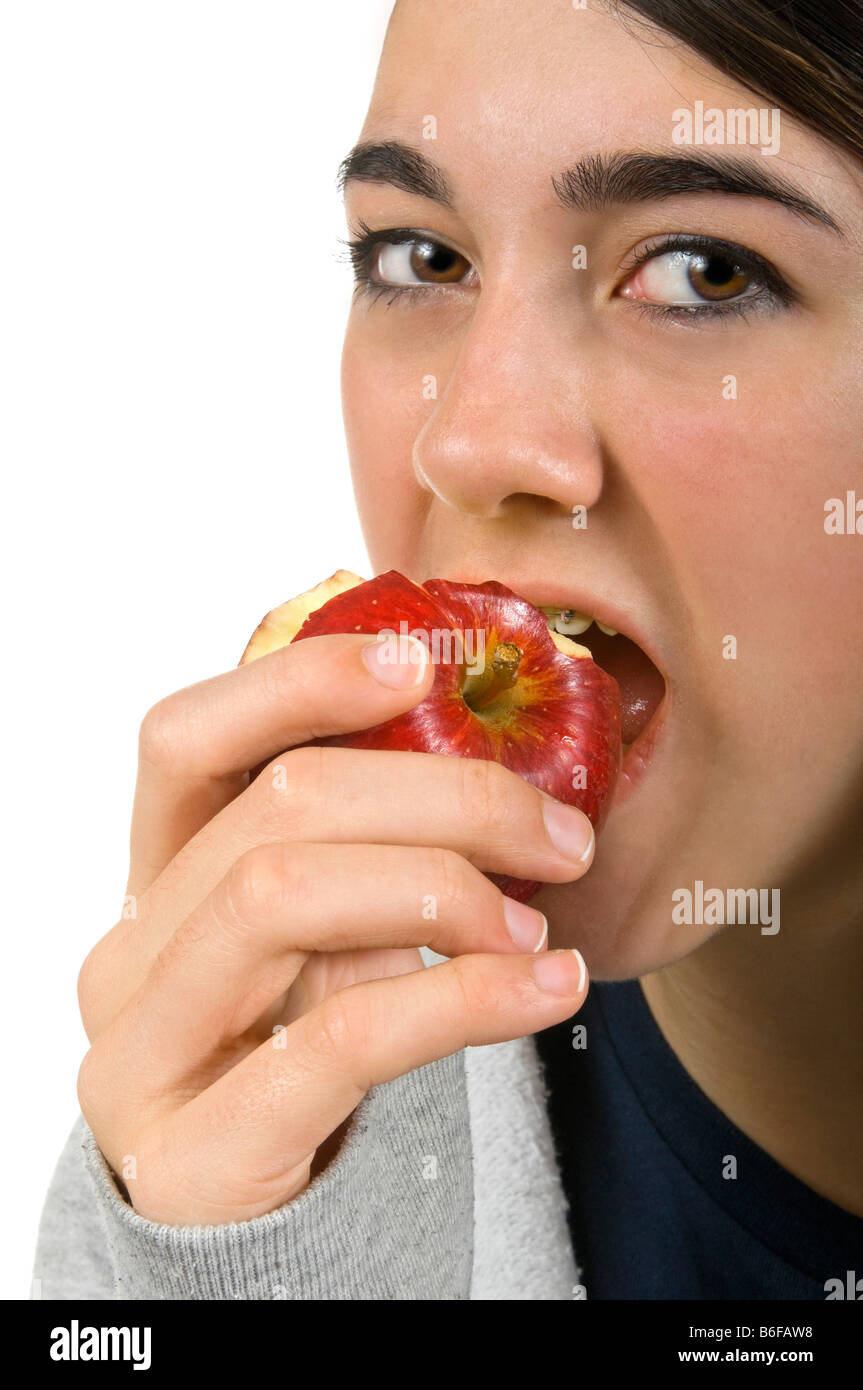Vertical close up portrait of an attractive young teenage girl eating a