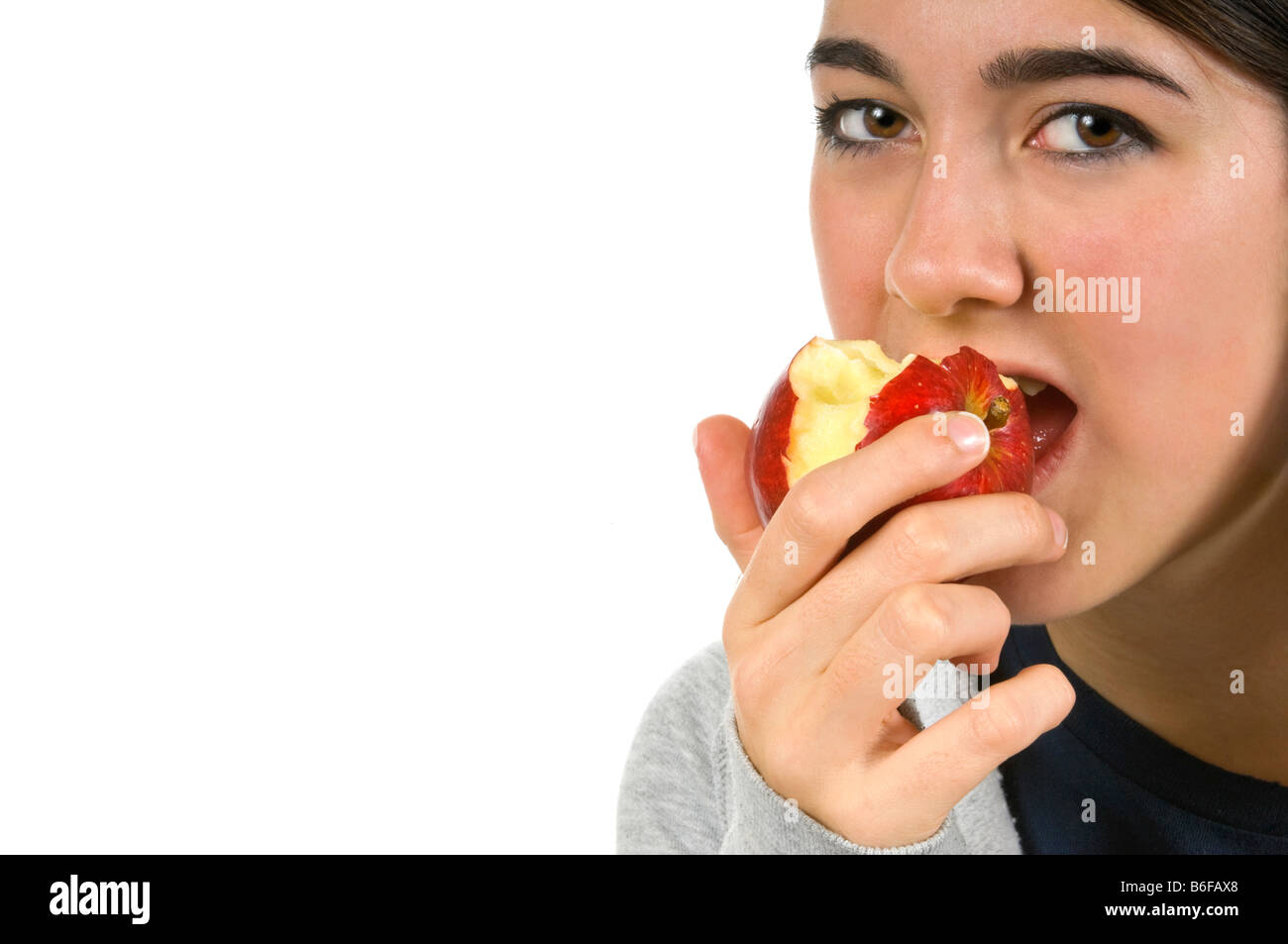 Horizontal close up portrait of an attractive young teenage girl eating
