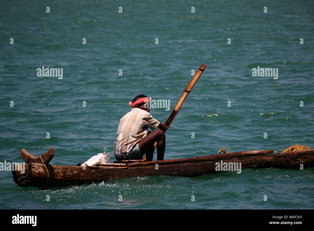 A fishermen sailing a wooden canoe Stock Photo
