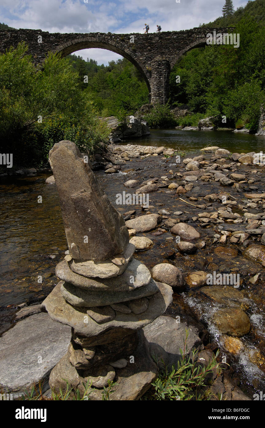 Stone cairn in front of arched stone bridge near Thines, Ardeche, Rhone Alps, France, Europe Stock Photo
