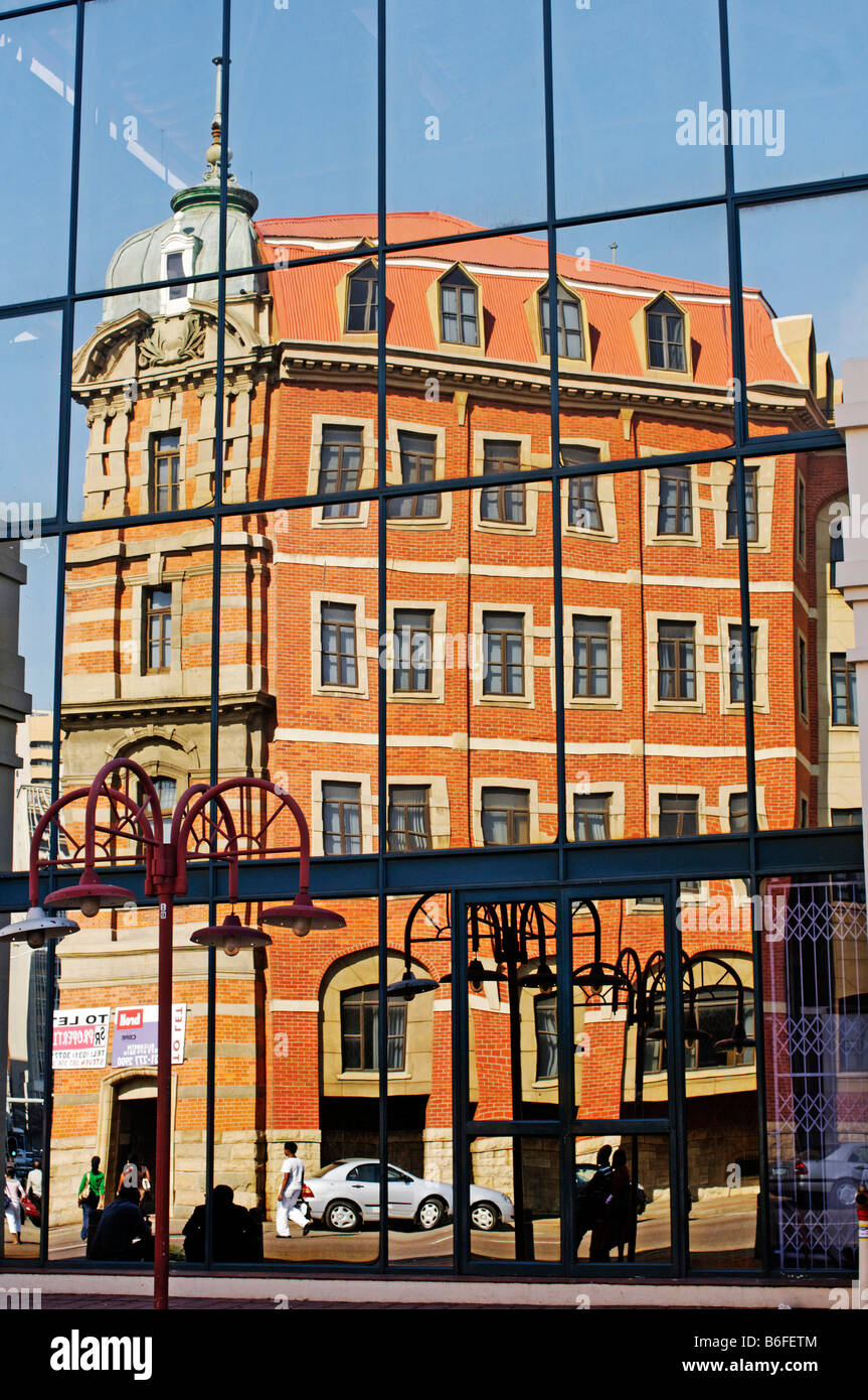 Reflection of an old brick building in a glass facade, Durban, Kwazulu