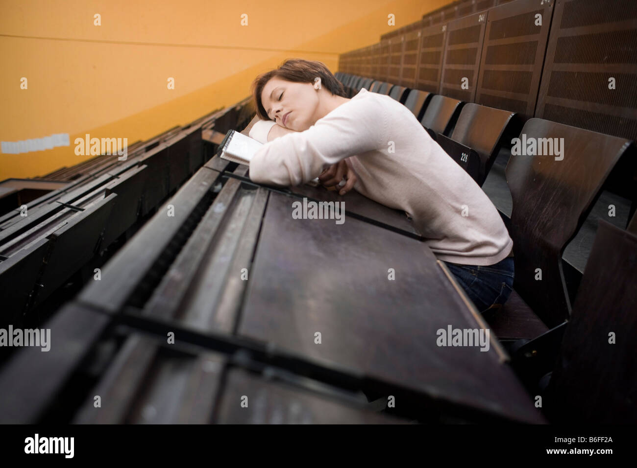 Female student in the lecture hall, sleeping Stock Photo