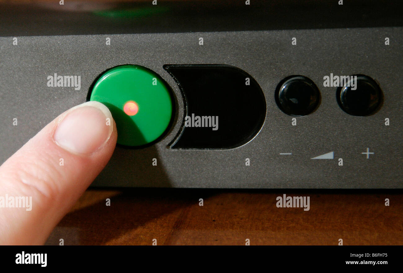 Finger pushing a standby button on a television, Regensburg, Bavaria, Germany, Europe Stock Photo