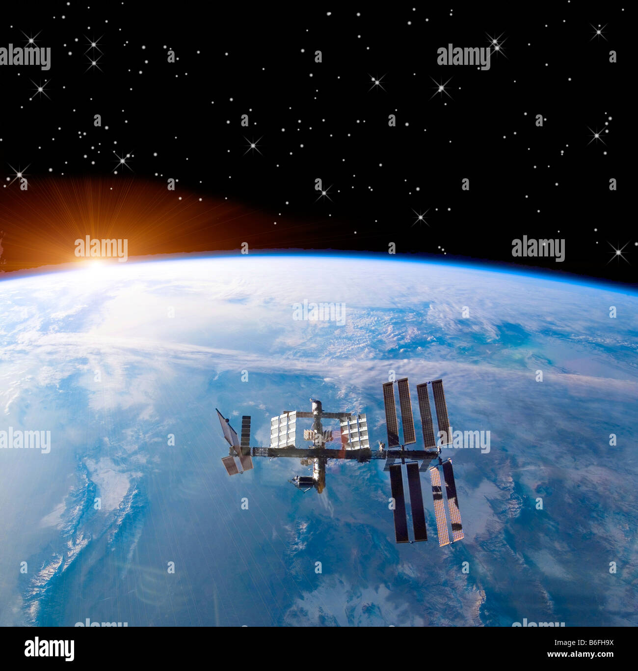 computer enhanced NASA image of International Space Station (ISS) flying above earth sunrise Stock Photo