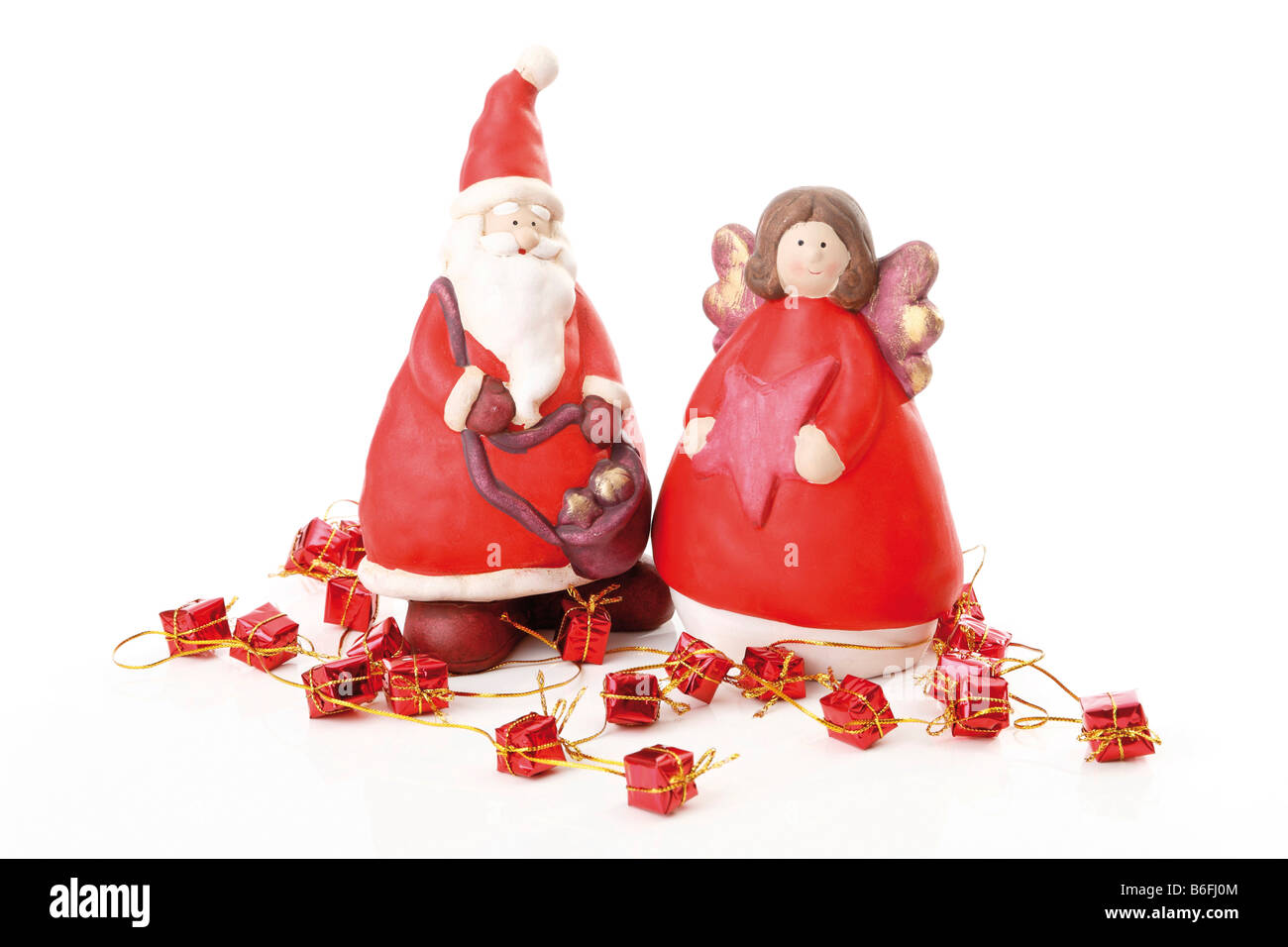 Father Christmas and angel figurines with presents Stock Photo