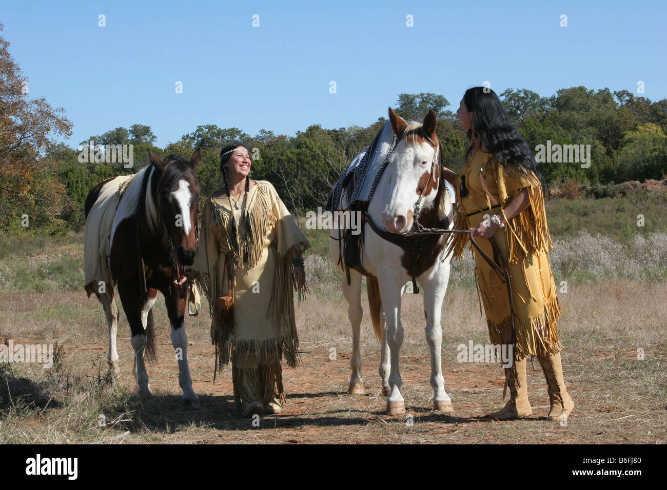 Two Native American Indian women walking their horses enjoying the day Stock Photo