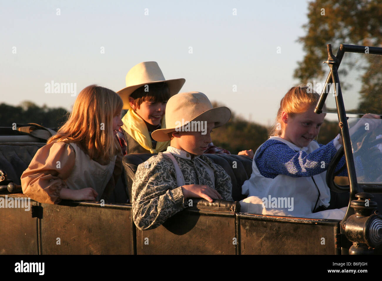 Four kids riding in an old car Stock Photo - Alamy