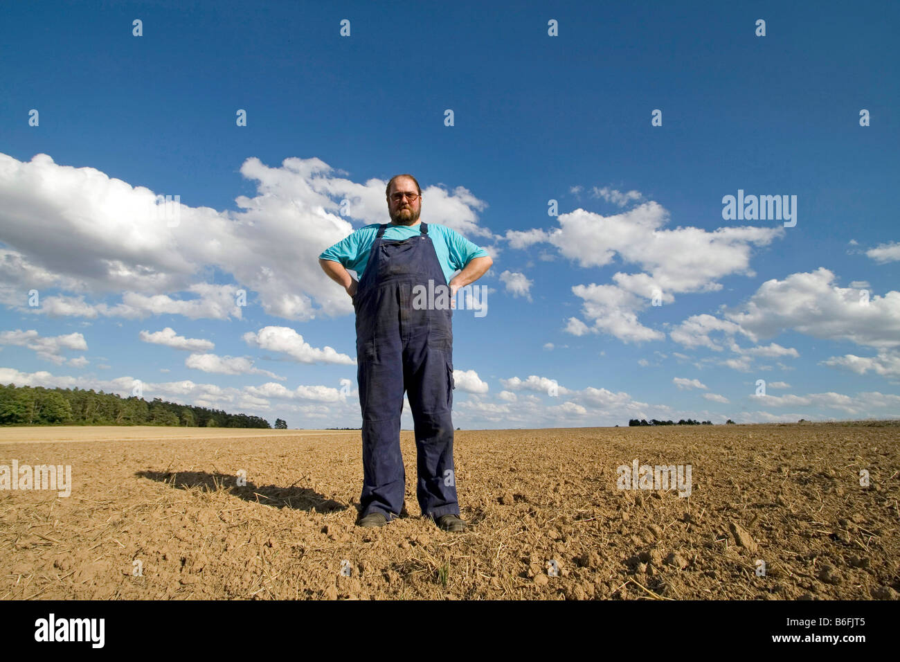 Farmer standing in a field Stock Photo