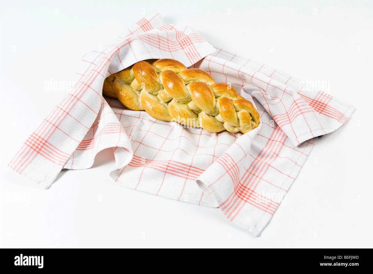 Braided bread or plaited loaf in a tea towel Stock Photo