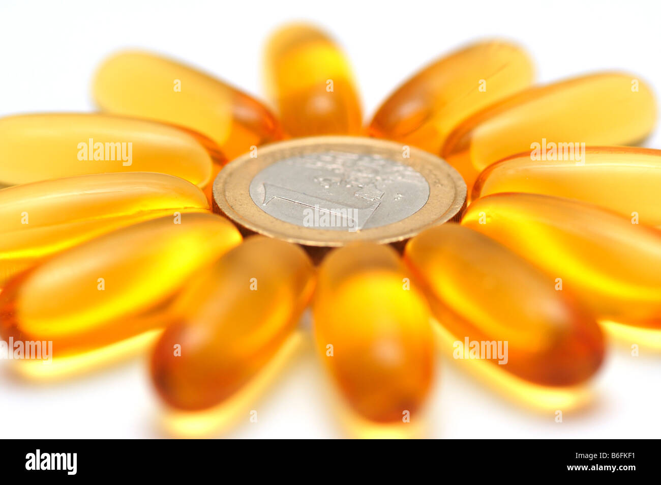 Medicine pills, capsules forming a flower in a ring around a coin Stock Photo