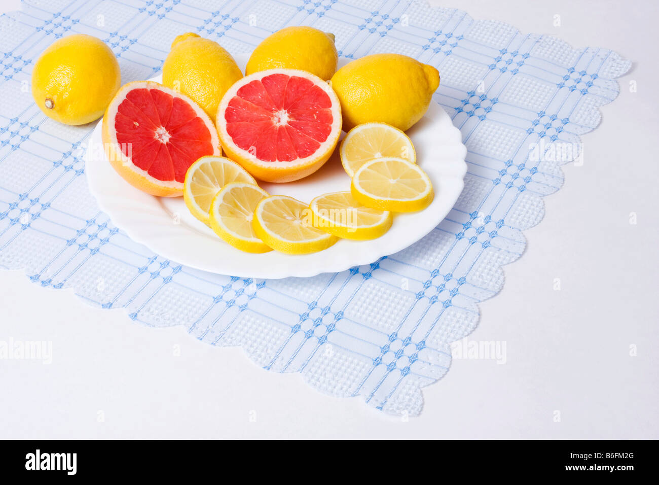 Cut yellow lemons and red grapefruits on dish Stock Photo