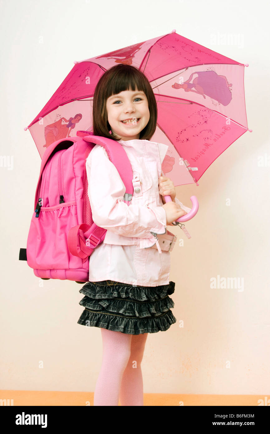Little girl, 6 years, with umbrella and schoolbag Stock Photo
