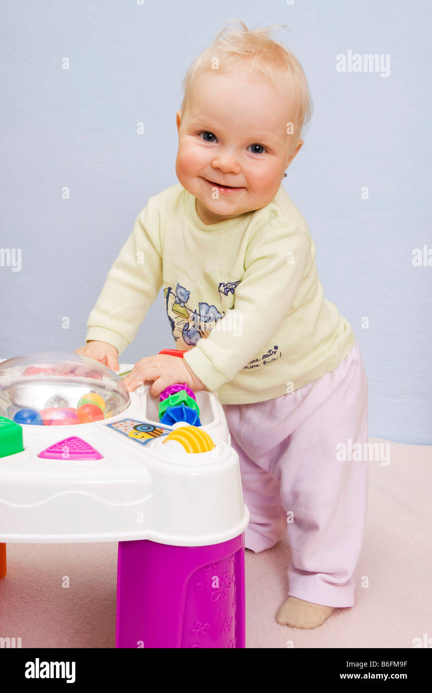 Baby girl, 9 months, at playing table Stock Photo