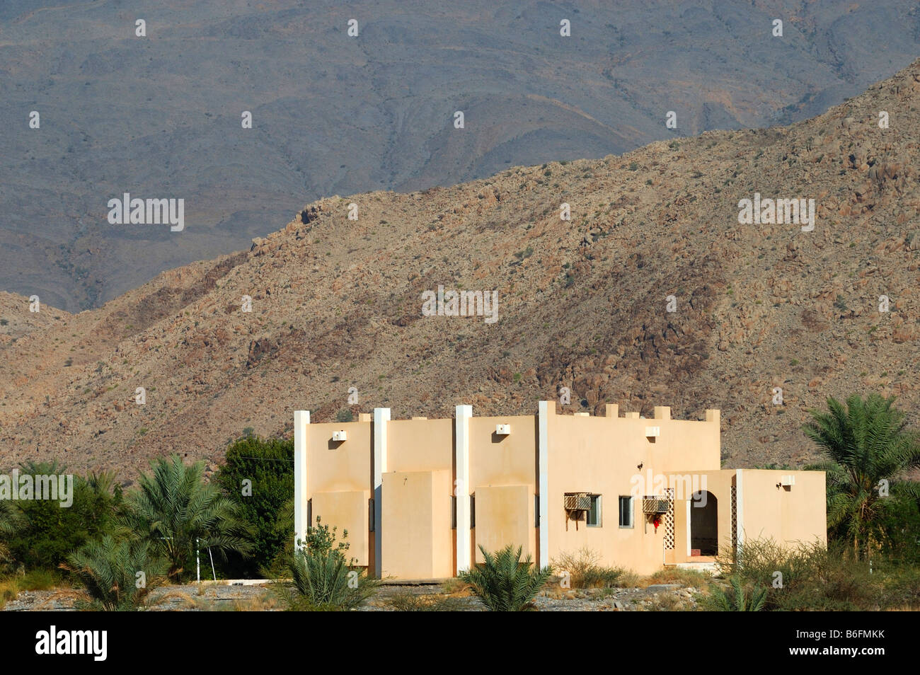 Modern residential building in a barren mountain landscape near Nizwa, Sultanate of Oman, Middle East Stock Photo
