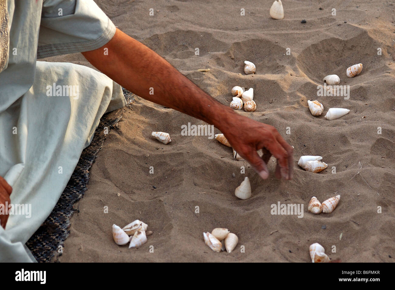 Man playing Shell Hawalis, the Omanian version of Mancala, Sultanate of Oman, Middle East Stock Photo