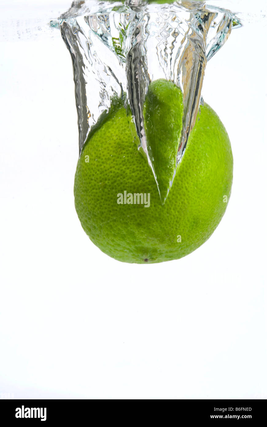 Lime falling into water Stock Photo