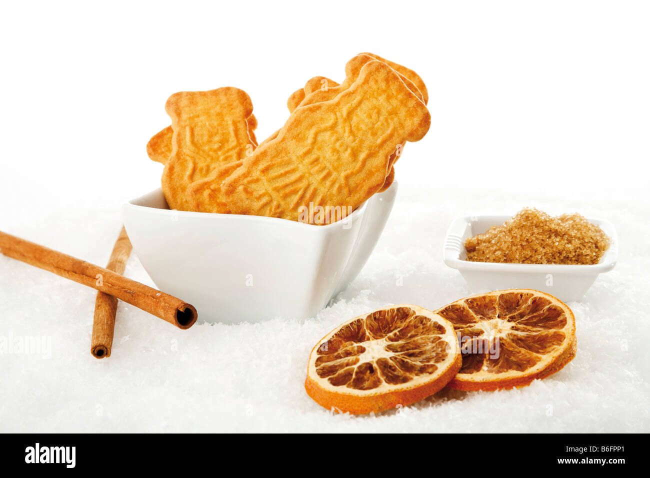 Spiced biscuits with brown sugar and orange slices in artificial snow Stock Photo