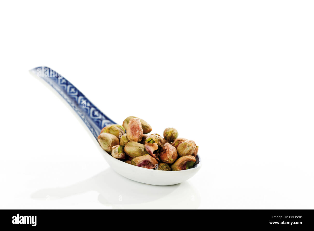 Pistachio nuts on an Asian spoon Stock Photo