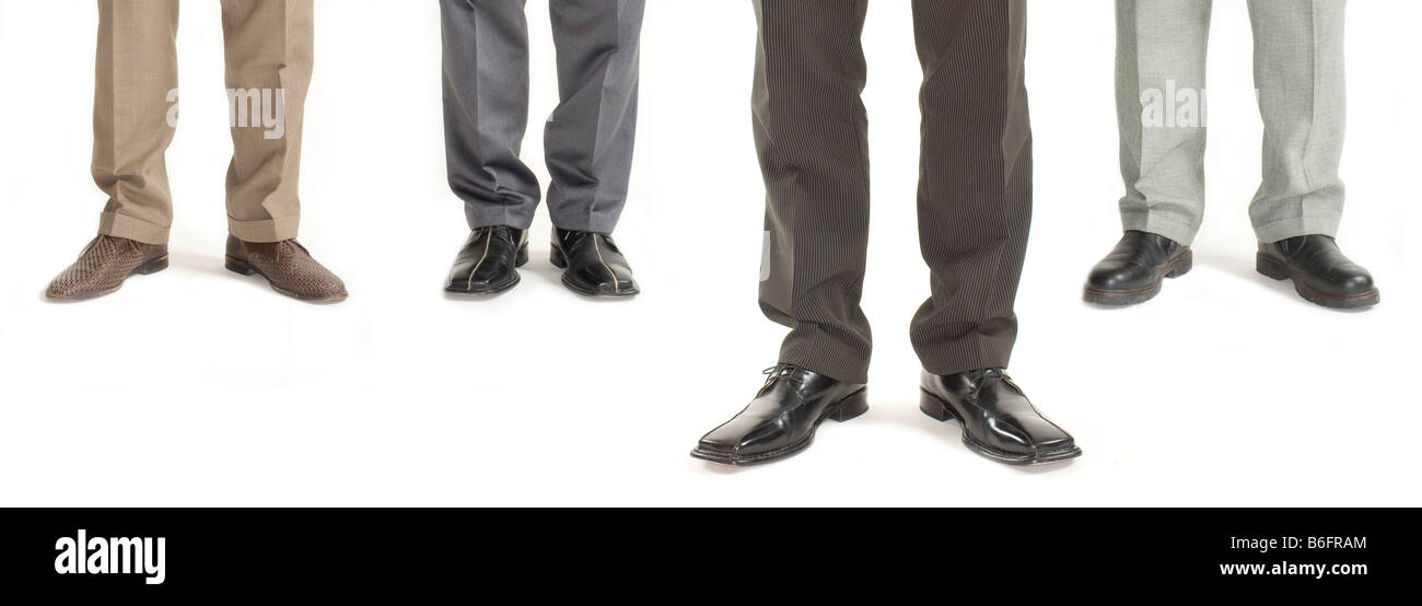 Four businessmen standing in a row with one standing further forward, detail of legs Stock Photo