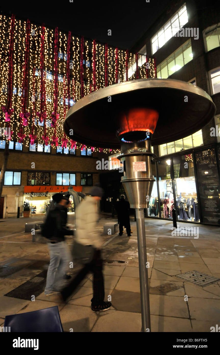 London West End at Christmas time outdoor gas heater beside tables for eating out similar to so called garden patio heaters Stock Photo