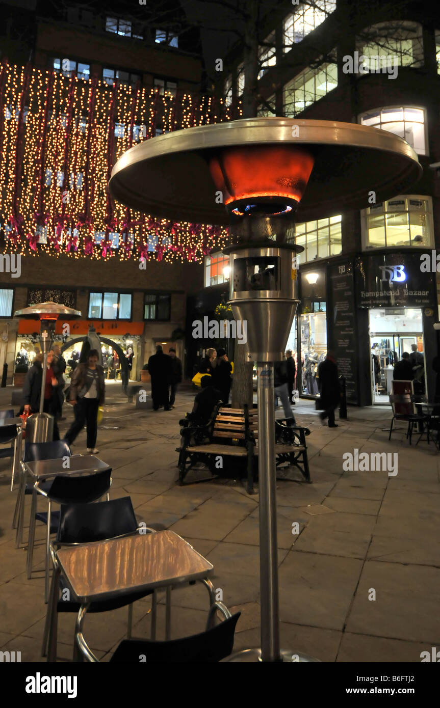 London West End at Christmas time restaurants providing outdoor gas heater beside tables for eating out similar to so called garden patio heaters UK Stock Photo